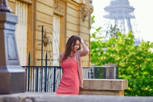 Beautiful young woman near the Eiffel tower — Stock Photo, Image