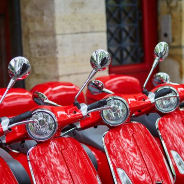 Parisli bir sokakta park edilmiş kırmızı retro scooter