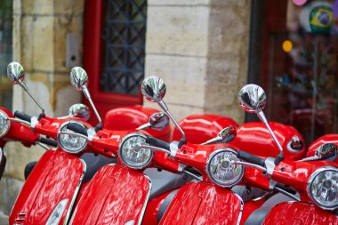 Parisli bir sokakta park edilmiş kırmızı retro scooter