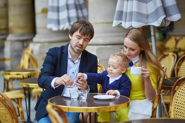 Happy family of three in Parisian cafe — Stok fotoğraf