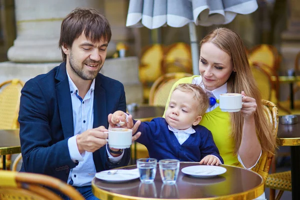 Счастливая семья из трех человек в парижском кафе — стоковое фото