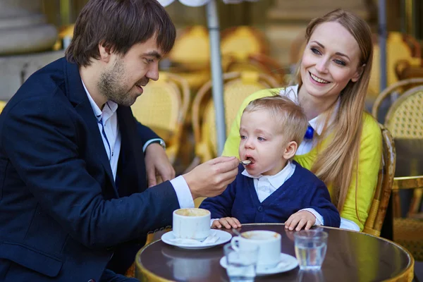 Счастливая семья из трех человек в парижском кафе — стоковое фото