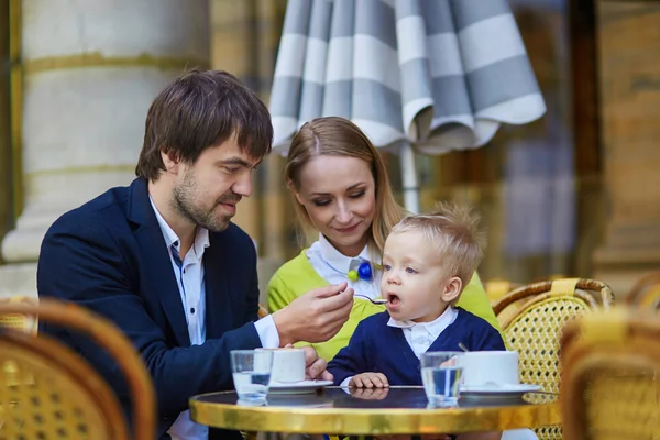 Família feliz de três em café parisiense — Fotografia de Stock