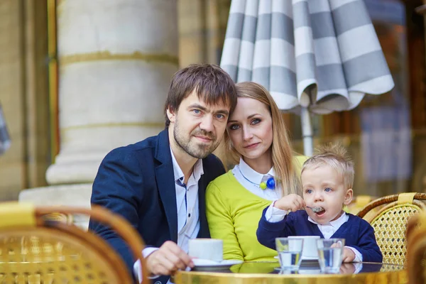 Happy family of three in Parisian cafe — Zdjęcie stockowe