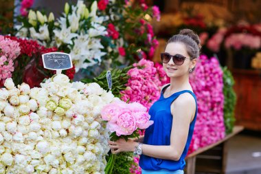 Beautiful young Parisian woman buying flowers