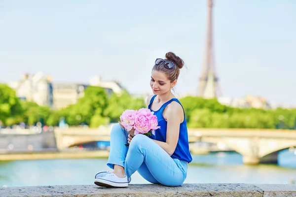 Young Parisian woman with pink peonies — Zdjęcie stockowe