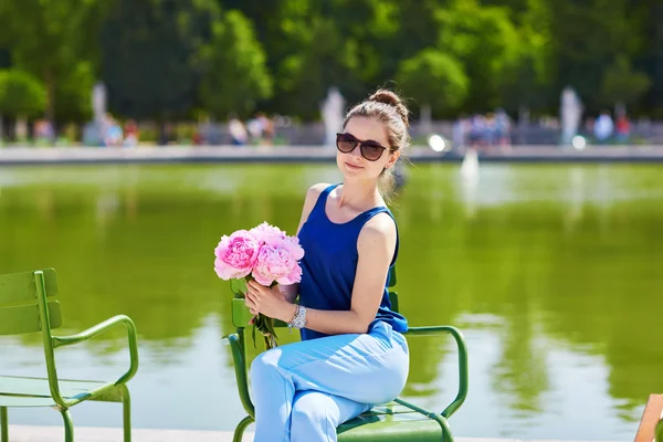 Young Parisian woman with pink peonies — Stockfoto