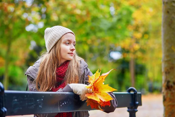 Girl sitting on a bench in park on a fall day — Stock Photo, Image