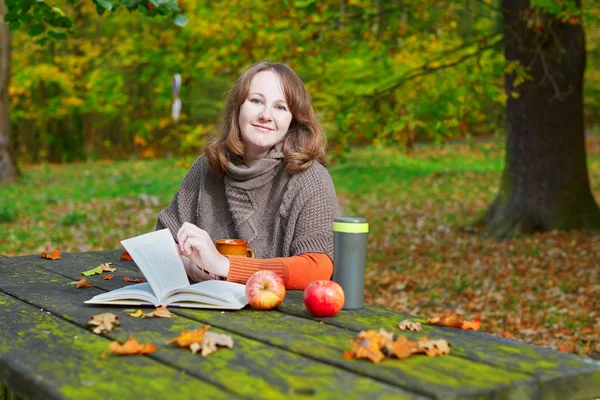 Girl having a picnic in park on a fall day — Stock Photo, Image