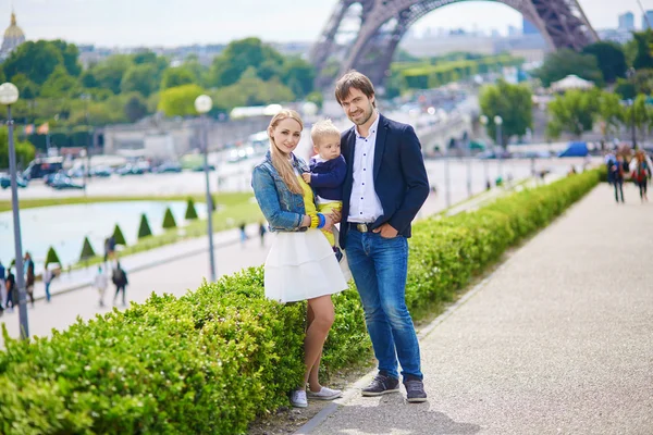 Glad familj på tre i Paris nära Eiffeltornet — Stockfoto