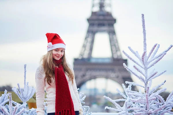 Girl in Santa hat near the Eiffel tower — Stock Photo, Image