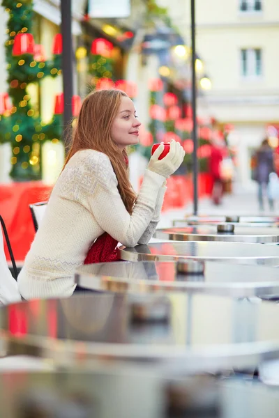 Dívka sedící v pařížské venkovní kavárna v době Vánoc — Stock fotografie