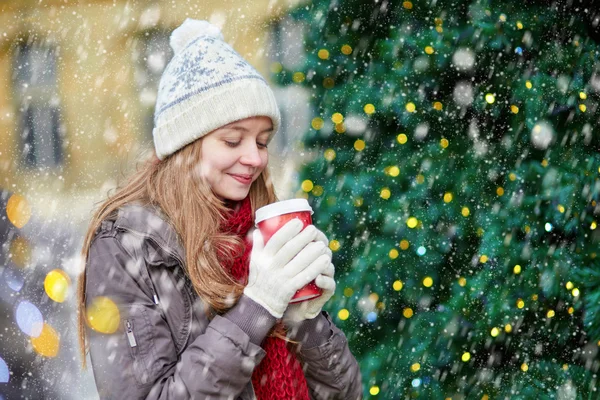 Girl drinking coffee near decorated Christmas tree — Stock Photo, Image