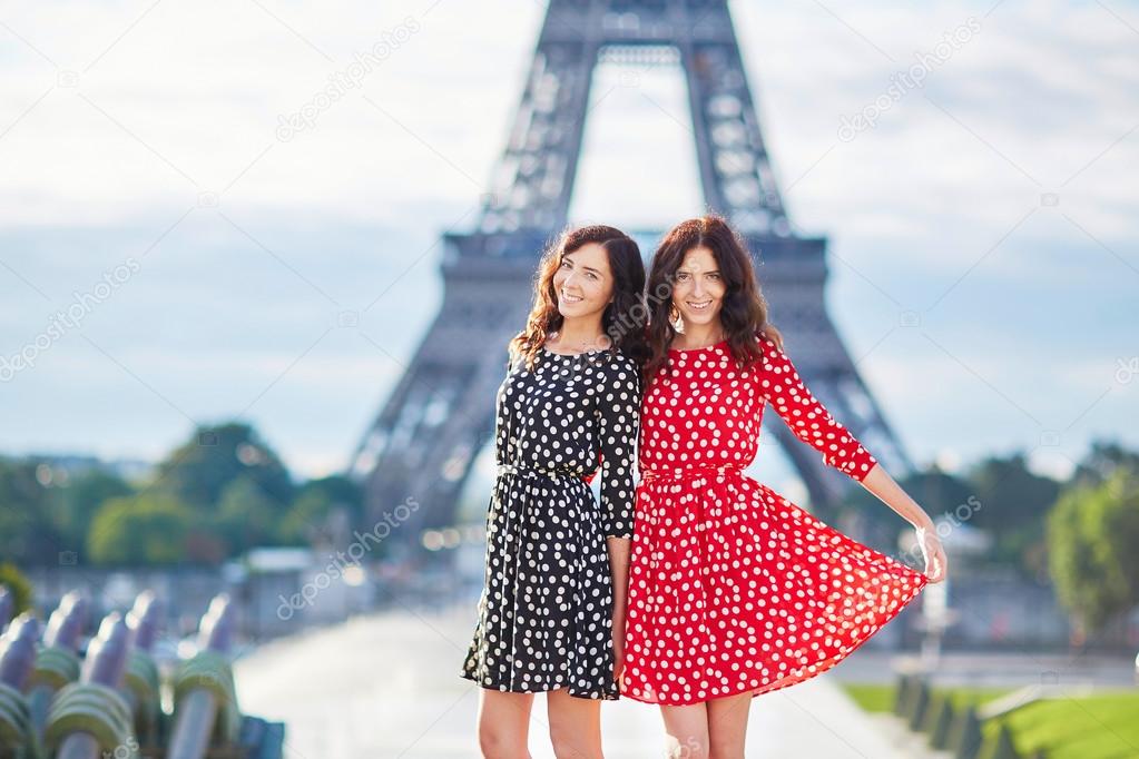 Twin sisters in front of the Eiffel tower in Paris, France