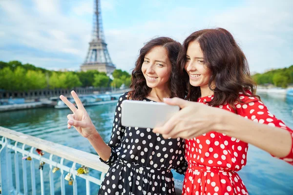 Beautiful twin sisters taking selfie in front of Eiffel Tower — Stock Photo, Image