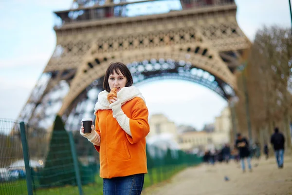 Žena s odnést kávu a croissant poblíž Eifellova věž — Stock fotografie