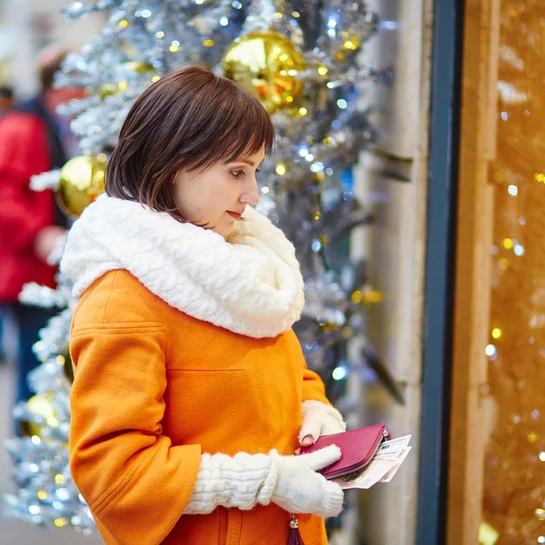 Worried young woman holding purse with Russian roubles