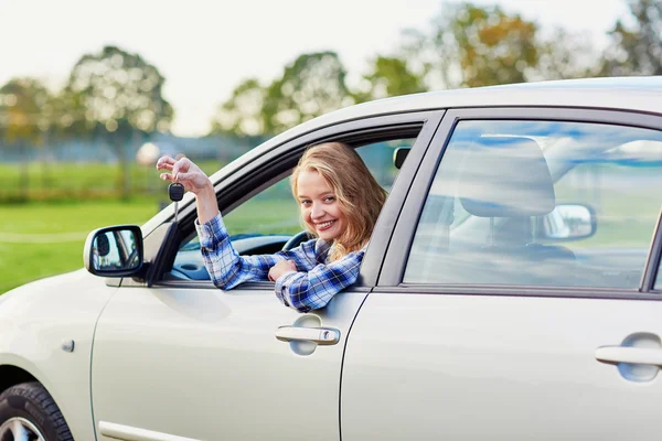 Bonito jovem motorista olhando para fora da chave de retenção do carro — Fotografia de Stock