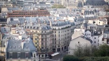 PARIS, FRANCE - 20 Ekim 2025: Haussmann tarzı binalar, arabalar ve ağaçlarla dolu tipik bir Paris sokağı manzarası