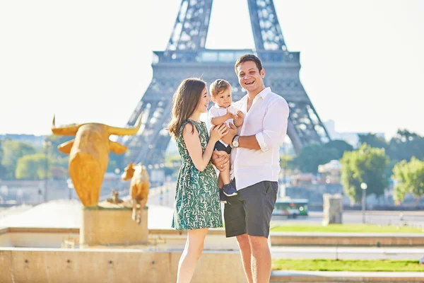 Happy family of three standing in front of the Eiffel tower — Stock Photo, Image