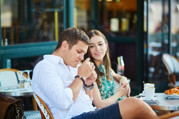 Jovem casal romântico em um aconchegante café ao ar livre em Paris, França Imagens Royalty-Free