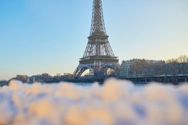 Fransa, Paris 'teki Eyfel Kulesi' nin manzarası. Yumuşak karla kaplı önü ve açık sabah gökyüzü..
