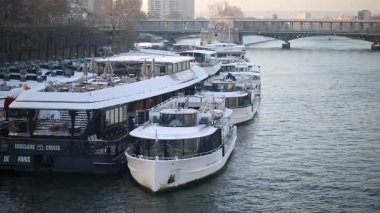 Paris, Fransa - 6 Ocak 2026: Karla kaplı çok sayıda nehir teknesinin Paris 'e yanaştığı kış manzarası.