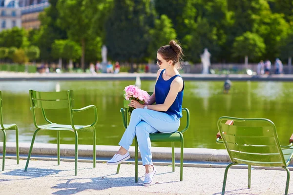 Parijse jongedame van roze pioenrozen in Tuileries — Stockfoto