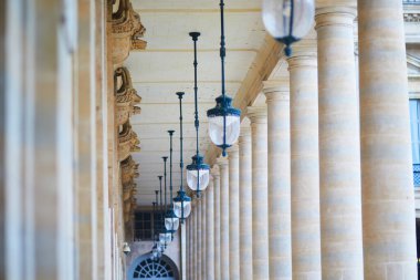Paris, Palais-Royal avlusunda simetrik taş sütunları ve asılmış klasik fenerleri olan zarif mimari sütunlar..