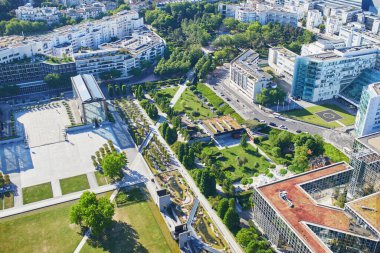 Güneşli bir yaz gününde arka planda yeşil ağaçlar, konut binaları ve Montparnasse Kulesi ile Paris 'in panoramik hava manzarası.