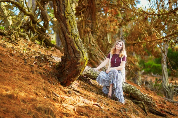 Menina romântica bonita sentada no tronco da árvore — Fotografia de Stock