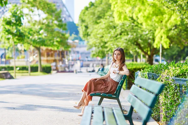 Pařížanka sedící na lavičce poblíž Eifellova věž — Stock fotografie