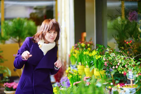 Beautiful young woman selecting flowers at market — Stock Photo, Image