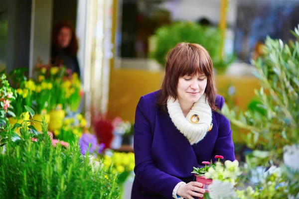 Beautiful young woman selecting fresh flowers — Stock Photo, Image