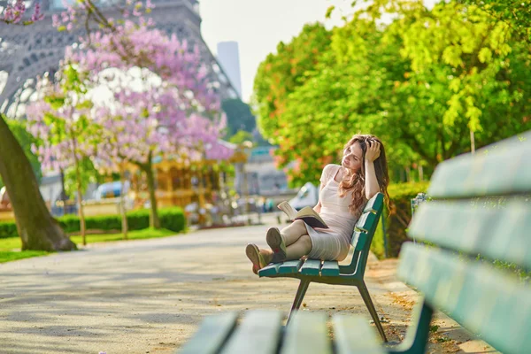 Beautiful young woman in Paris, reading a book — Stock Photo, Image