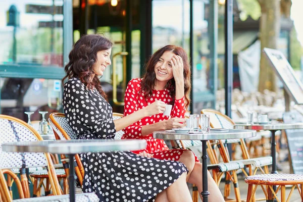 Beautiful twin sisters drinking coffee — Stock Photo, Image