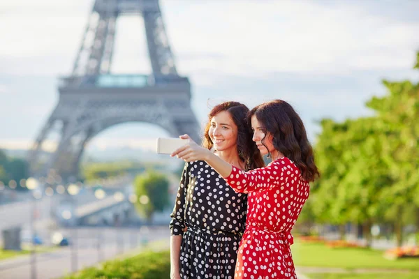 Vackra tvillingsystrar tar selfie framför Eiffeltornet — Stockfoto