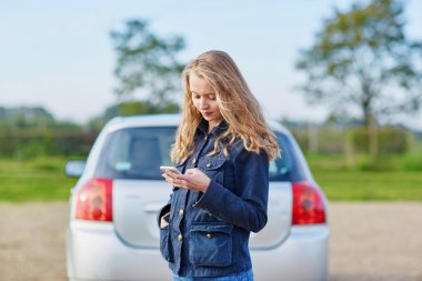 Kadın yardım istiyor kırık bir araba yakınındaki yolda