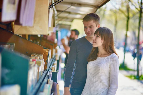 Романтическая пара в Париже выбирает книгу у книготорговца — стоковое фото