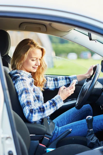 Žena pomocí její smartphone za jízdy auto — Stock fotografie