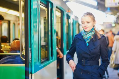 Paris underground platformu üzerinde bir tren bekleyen kadın