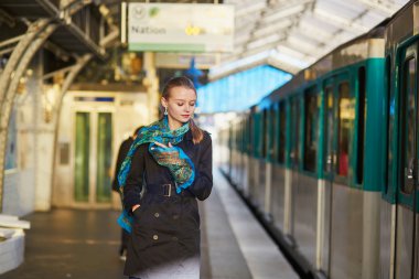 Paris underground platformda bir tren bekleyen genç kadın