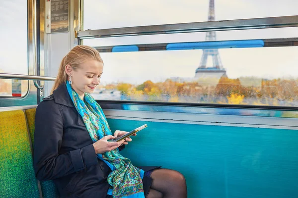 パリの地下鉄の列車の旅と読書の美しい若い女性 — ストック写真