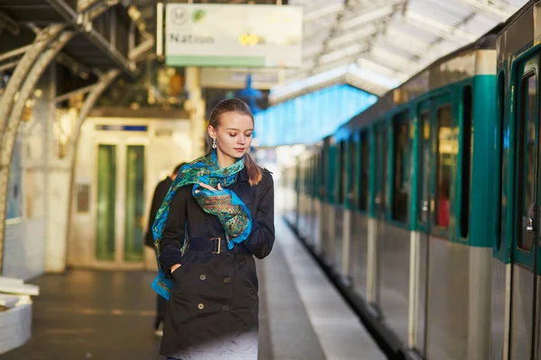 Joven mujer esperando un tren en la plataforma del metro parisino — Foto de Stock