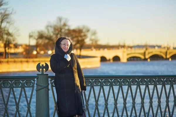Mujer de mediana edad en el puente en San Petersburgo, Rusia en un día soleado de invierno — Foto de Stock