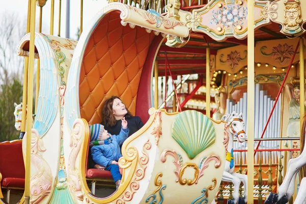 Ung mor med sin bedårande lilla son på parisiska karusell — Stockfoto