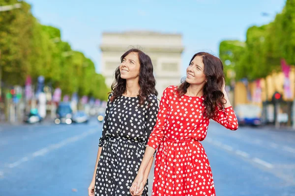 Beautiful twin sisters in front of Arc de Triomphe — Stock Photo, Image
