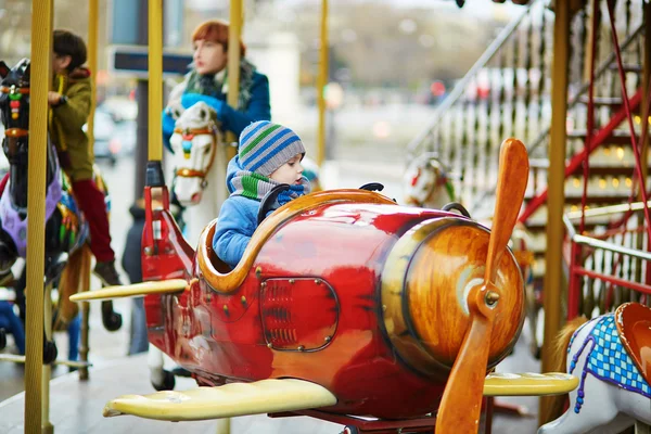 Chłopiec biorąc jazdy w płaszczyźnie na merry-go-round — Zdjęcie stockowe