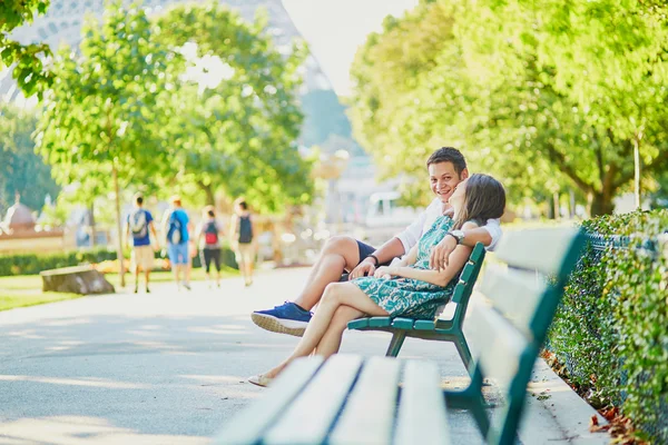 Feliz pareja de citas en un banco en un parque parisino — Foto de Stock