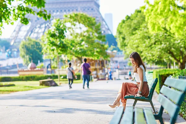 Pařížanka sedící na lavičce poblíž Eifellova věž — Stock fotografie